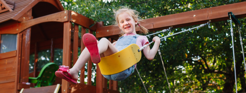 Happy little girl on a swing